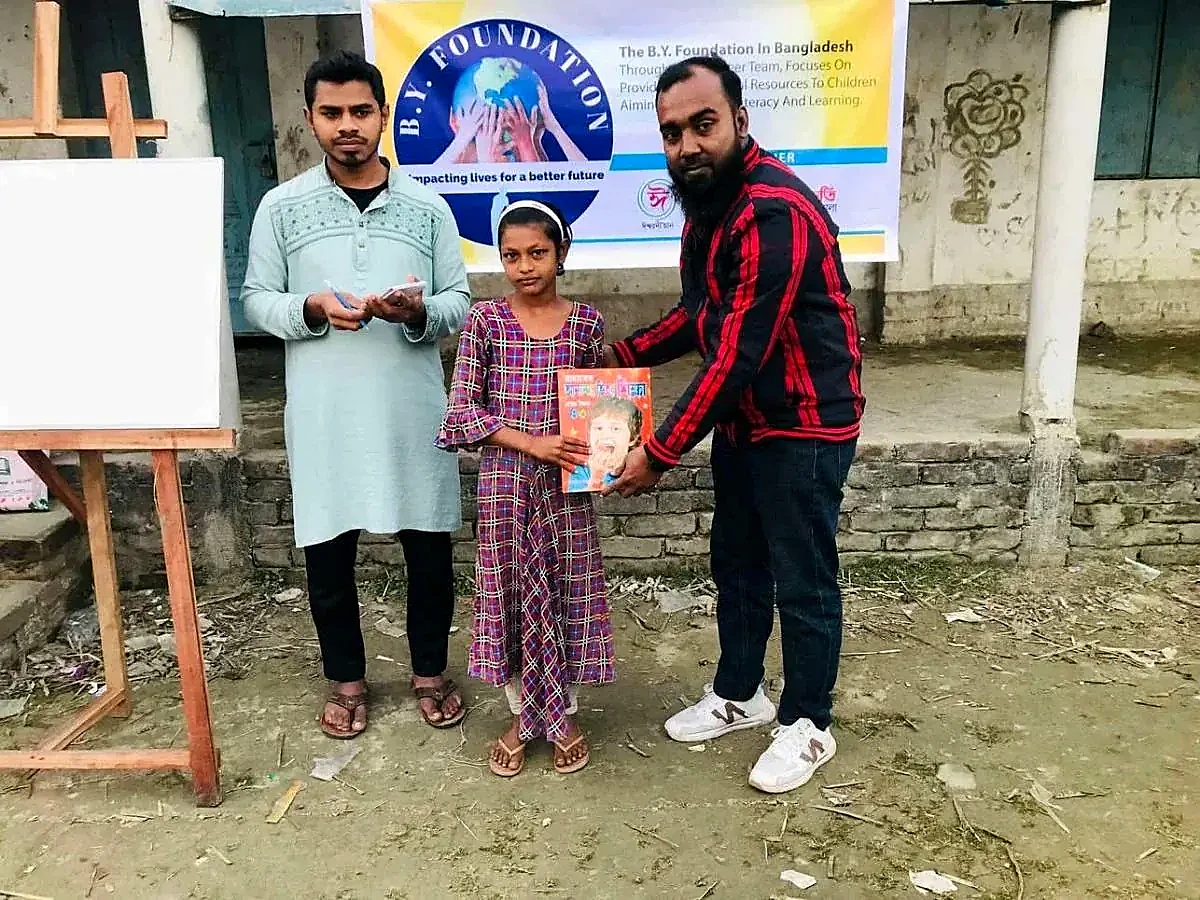 Learning materials handed to a child in Bangladesh
