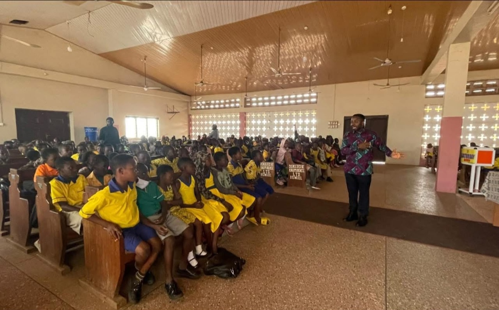 Foundation representative speaking to children at a school assembly