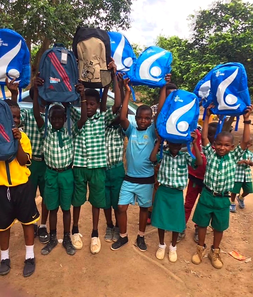 Children holding school bags from the foundation